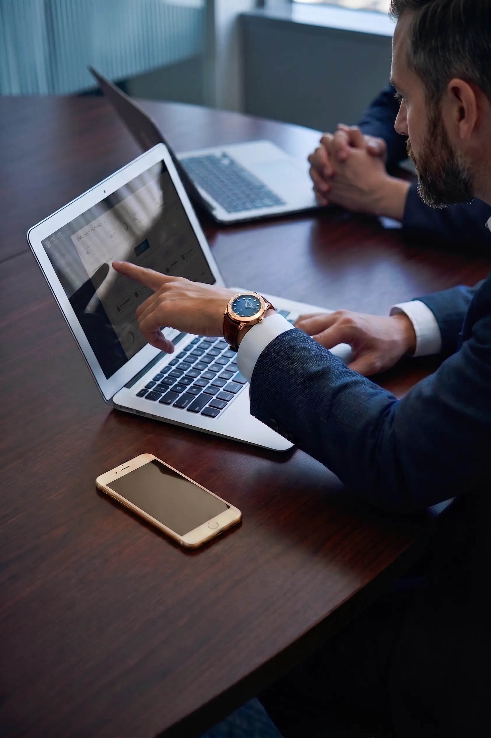 Professional pointing at screen during a meeting